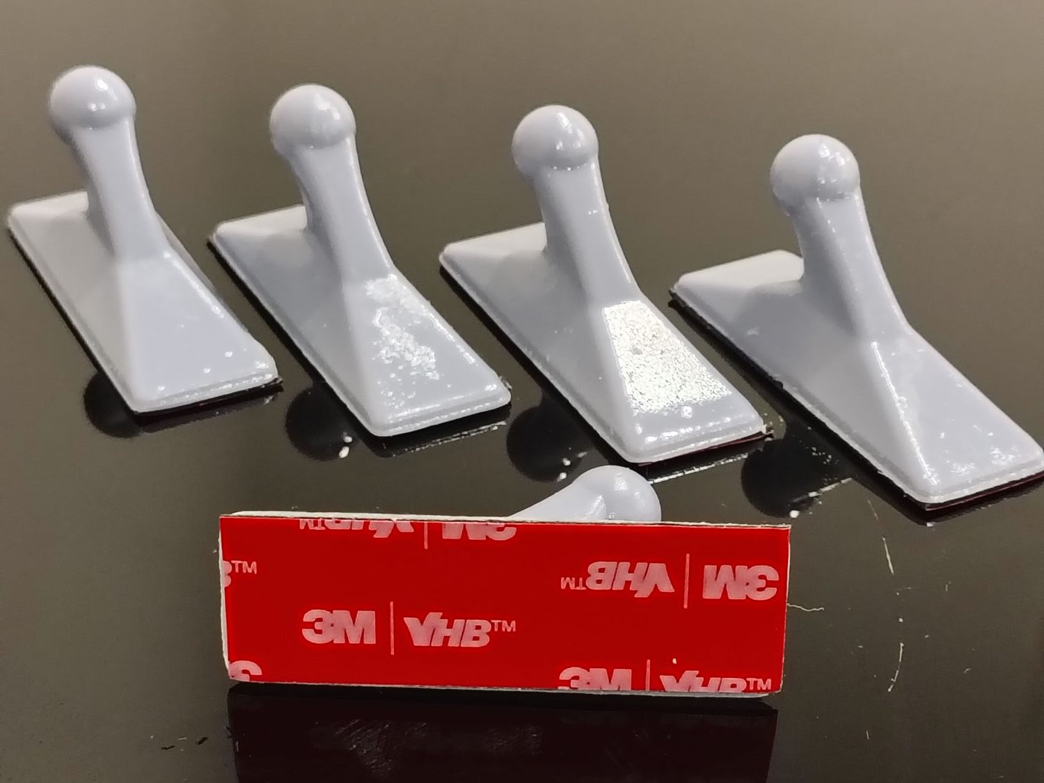 Five white 3D printed resin coat hooks with 3M VHB adhesive pads